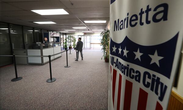 March 26, 2020 Marietta: The Marietta City Hall is open for business, but the lobby is mostly quiet and a six foot barrier seperates Marietta Police Officer Chris Rader from visitors on Thursday, March 26, 2020, in Marietta. A patchwork of local officials, not the governor or president, this week ordered the closure of businesses across the state and forced people to shutter inside their homes over fears of COVID-19.       Curtis Compton ccompton@ajc.com