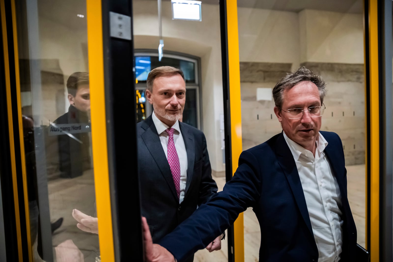 Finance Minister Christian Lindner, center, leaves the Reichstag building alongside Free Democratic Party's Stephan Thomae, a member of the German Bundestag, after a parliamentary group meeting following Lindner's dismissal by the Federal Chancellor Olaf Scholz, in Berlin, Wednesday, Nov. 6, 2024. (Christoph Soeder/dpa via AP)