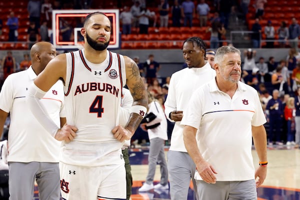 Auburn forward Johni Broome (4) and head coach Bruce Pearl walk off the court after losing to Alabama in overtime in an NCAA college basketball game, Saturday, March 8, 2025, in Auburn, Ala. (AP Photo/Butch Dill)