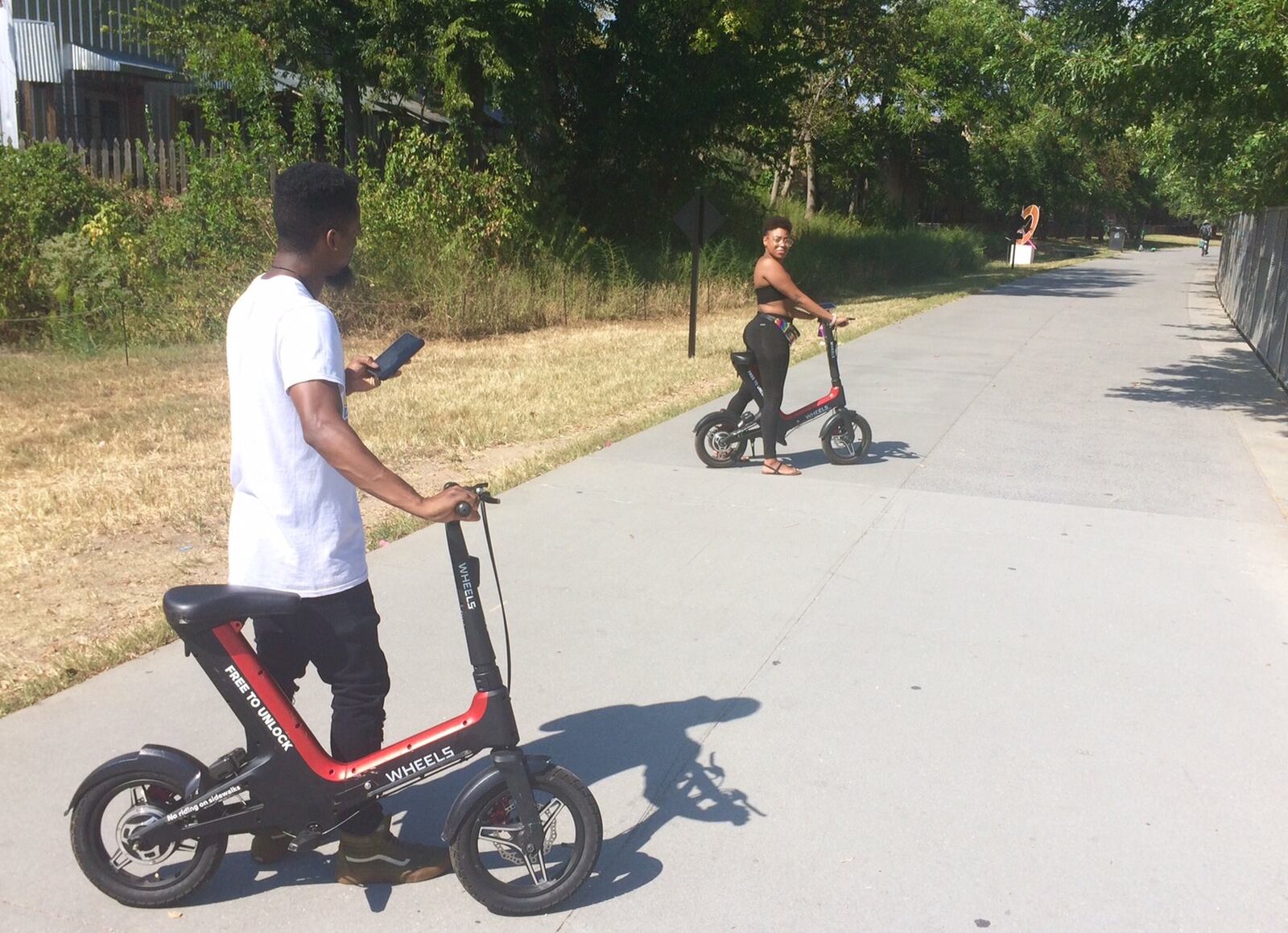 Taja Edwards (right) and Elijah Bolden try to get the Wheels device moving on the Beltline. Photo by Bill Torpy