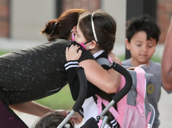 Kenia Jakeline hugs Alec Herrerd on her day of kindergarten Monday at Lake City Elementary School in Morrow on Aug. 2, 2021. (Steve Schaefer for the Atlanta Journal-Constitution)