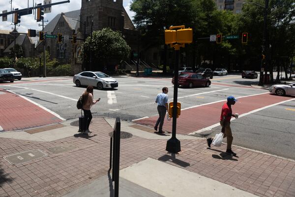 Pedestrians walk on Peachtree on Wednesday, July 12, 2023 in Atlanta. (Michael Blackshire/Michael.blackshire@ajc.com)