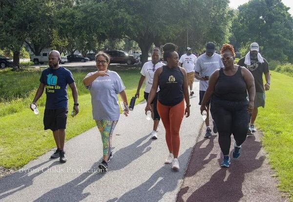 Attendees walk together along the Lake Mayer trail at the Healthy Savannah Faith and Health Coalition Faith Walk event. (Photo Courtesy of Byron Childs Productions)