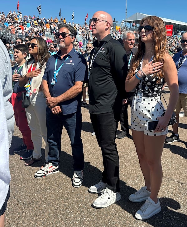 Michael Andretti, third from left, stands with his son, Mario, left, wife Jodi Ann, second from left, and Andretti Global new owner Dan Towriss, second from right, with his wife Cassidy Marie, right, before the Grand Prix of St. Petersburg auto race Sunday, March 2, 2025, in St. Petersburg, Fla. (AP Photo/Jenna Fryer)