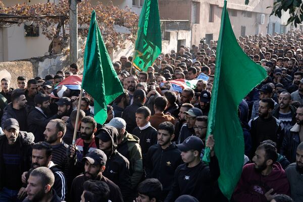 Mourners carry Hamas flags and the bodies, wrapped with the Palestinian flag, of Akram Abu Arrah and Mohammad Ghannam, both killed in an airstrike Israel said targeted a militant cell, during their funeral in the West Bank village of Al-Aqaba, Tuesday Dec. 3, 2024. (AP Photo/Majdi Muhammad)