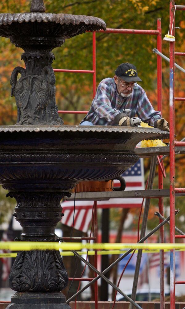 Nov. 10, 2009: Contractor Dan Spinney removes the damaged primer from the Marietta Square fountain. The fountain is being "re-refurbished." It had rained the day after the paint job the previous year, which damaged the primer.