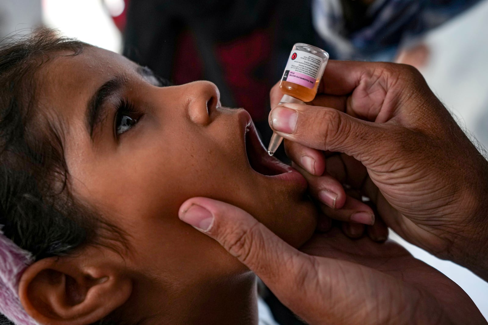 A health worker administers a polio vaccine to a child at a hospital in Deir al-Balah, central Gaza Strip, Sunday, Sept. 1, 2024. (AP Photo/Abdel Kareem Hana)