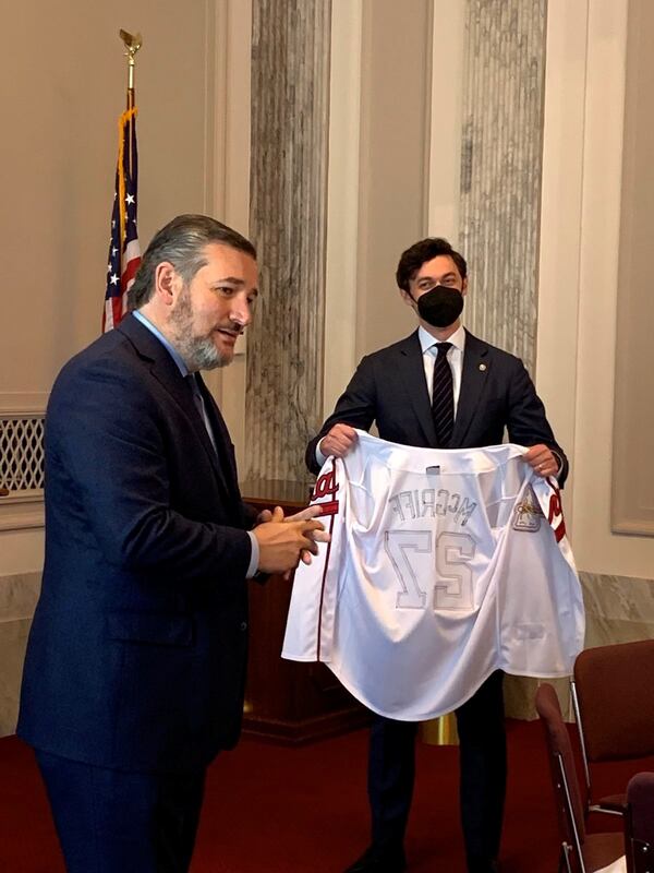 U.S. Sen. Jon Ossoff presents a Fred McGriff jersey to U.S. Sen. Ted Cruz after the Texas Republican lost a World Series bet.