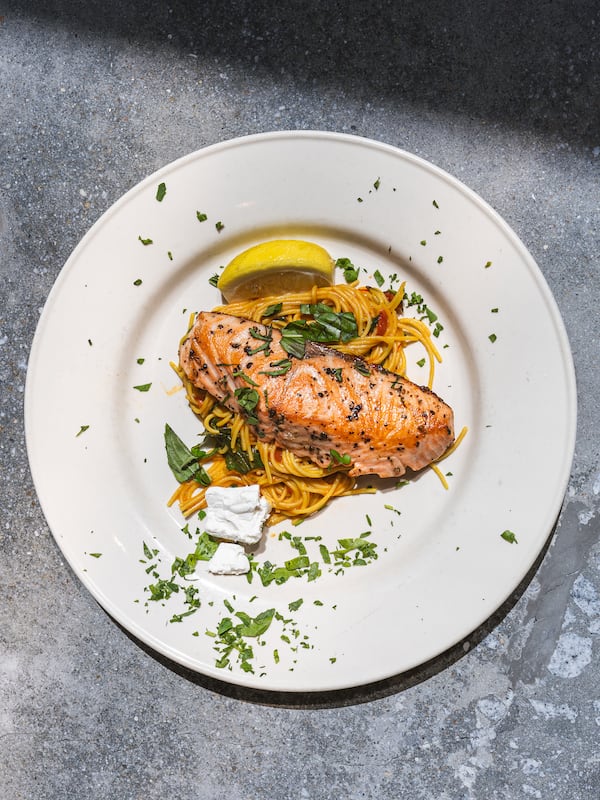 Chef Kameel Srouji and chef Yumara Nash cook salmon and pasta together in the Aviva by Kameel kitchen. Nash, 12, has built a following on social media for her cooking videos. Courtesy of J. Alburi/the Imprints