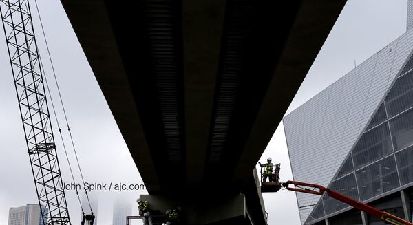 Work continues near Mercedes-Benz Stadium ahead of Friday afternoon storms. JOHN SPINK / JSPINK@AJC.COM