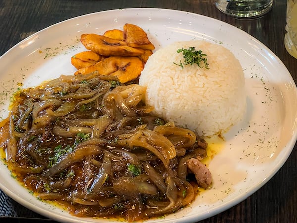 Many of the larger offerings at Arepa Grill Kitchen & Wine are Venezuelan comfort food, such as bisteck encebollado, a dish of thin beef steaks smothered in onions and brown gravy. (Henri Hollis/henri.hollis@ajc.com)