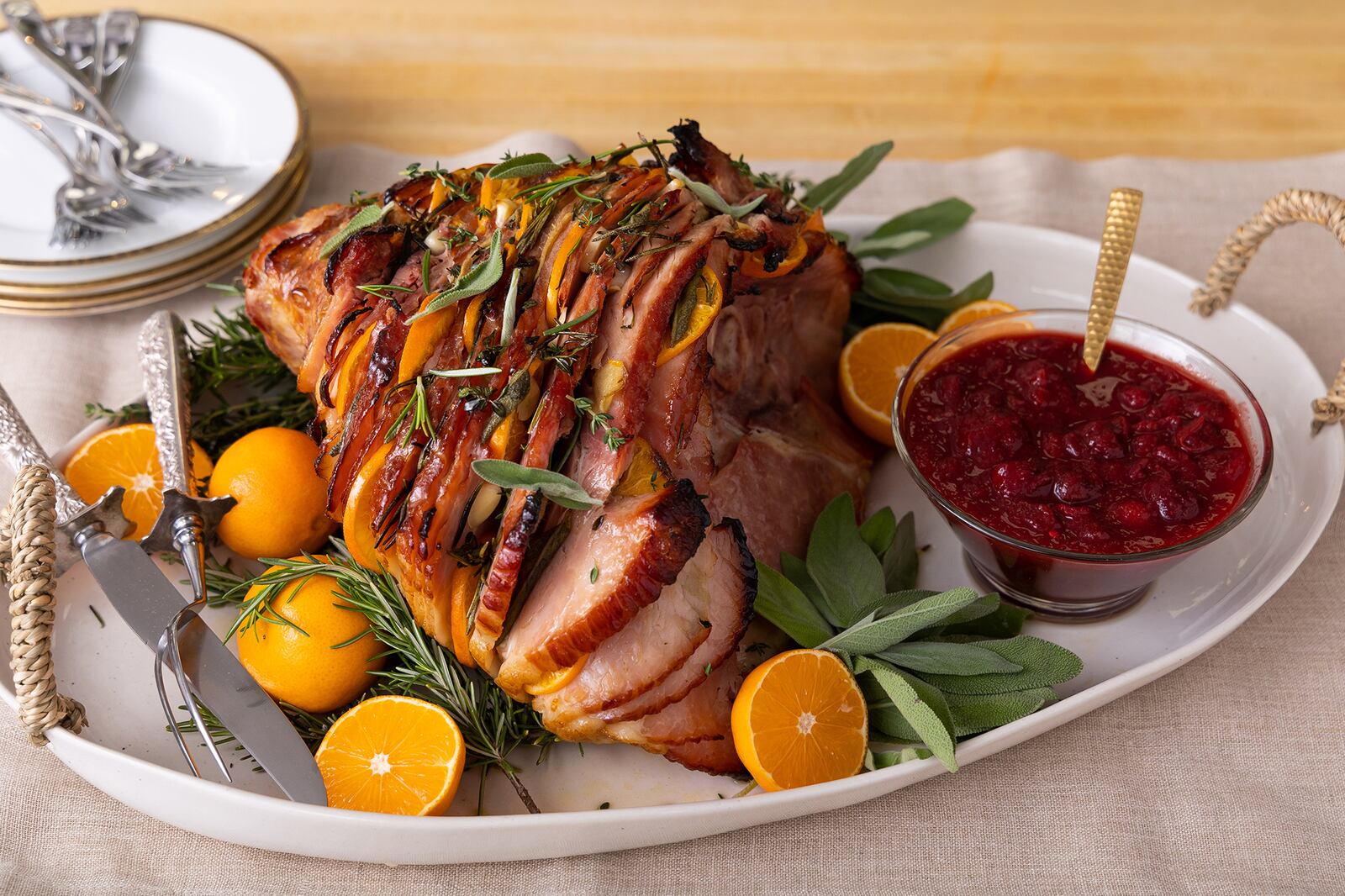 Winter citrus and fresh aromatics, like garlic and ginger, and herbs tucked into a spiral-cut ham transform it for the holiday table with little additional cost or effort. (Courtesy of Brooke Slezak)