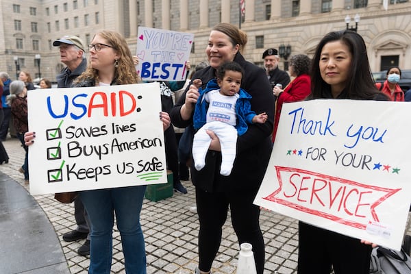 United States Agency for International Development (USAID) supporters hold banners as USAID workers retrieve their personal belongings from the USAID's headquarters in Washington, Thursday, Feb. 27, 2025. (AP Photo/Manuel Balce Ceneta)