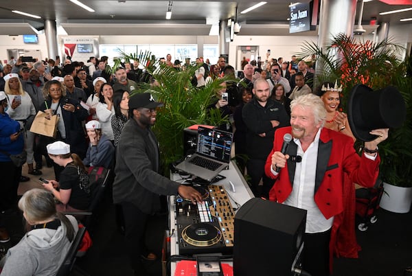 Richard Branson, founder of the Virgin Group, speaks to customers and hints they will receive a gift as Virgin Voyages and Delta host a full departure gate takeover prior to the flight's boarding at Hartsfield-Jackson Atlanta International Airport, Thursday, Feb. 29, 2024, in Atlanta. Sir Richard Branson, Delta Air Lines and Virgin Voyages surprised customers on Delta Flight 1946 (from ATL to SJU), gifting all an-board a free cruise to celebrate all-new itineraries and the brand’s growing presence in San Juan later this year. (Hyosub Shin / Hyosub.Shin@ajc.com)