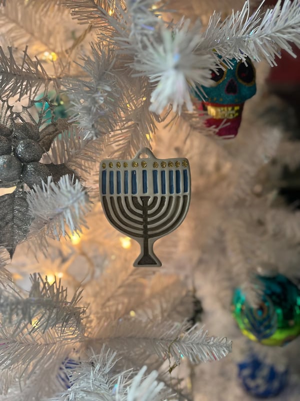 A menorah ornament adorns a white Christmas tree in the home of Holly Firfer Arnold and her husband Shawn Arnold. The couple celebrates both Christmas and Hanukkah.