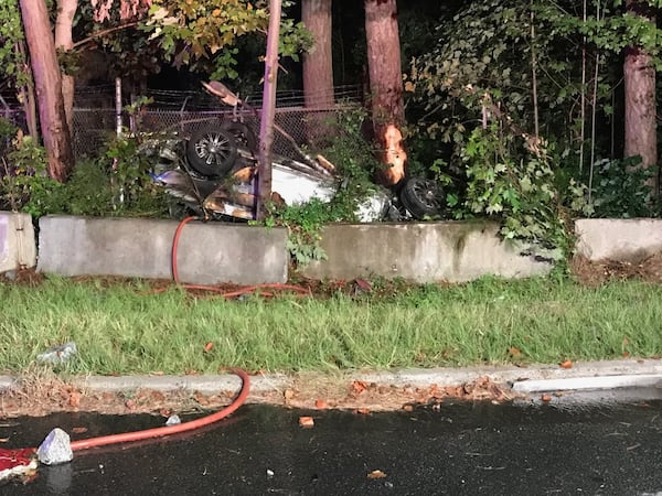 Megan Mosholder's Pontiac G6 left the road and landed upside down, wedged among these trees, before catching fire. CONTRIBUTED: MARIETTA FIRE DEPARTMENT