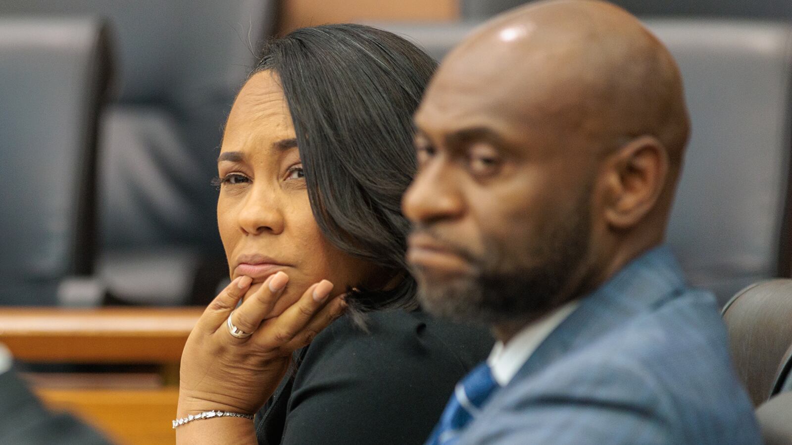 District Attorney Fani Willis (center), nest to Nathan Wade, a special prosecutor, reacts to proceedings at Fulton County Superior Court on Thursday, July 21, 2022.  State Sen. Burt Jones filed a motion to remove Willis from the Fulton County Trump investigation because she held a fundraiser for Jonesâ€™ Democratic opponent Charlie Bailey. (Arvin Temkar / arvin.temkar@ajc.com)