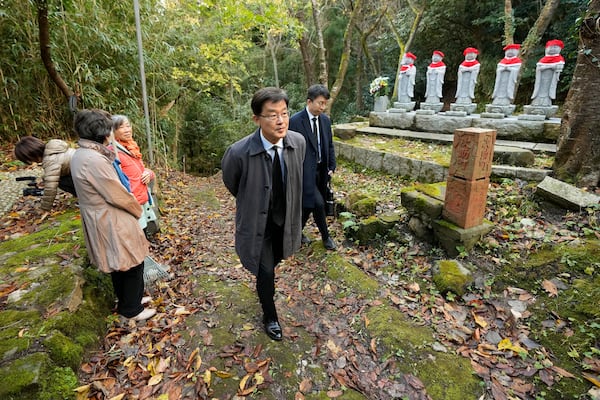 South Korean Ambassador to Japan Park Cheol-hee, center, arrives to join the relatives of Korean victims and South Korean officials to hold a memorial service in Sado, Niigata prefecture, Japan, Monday, Nov. 25, 2024. (AP Photo/Eugene Hoshiko)