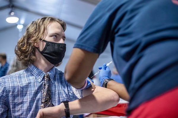 Marietta resident Neil Rossman, 23, receives his first COVID-19 vaccine shot at a DeKalb County Board of Health vaccination site at the Doraville MARTA transit station on Monday. (Alyssa Pointer / Alyssa.Pointer@ajc.com)