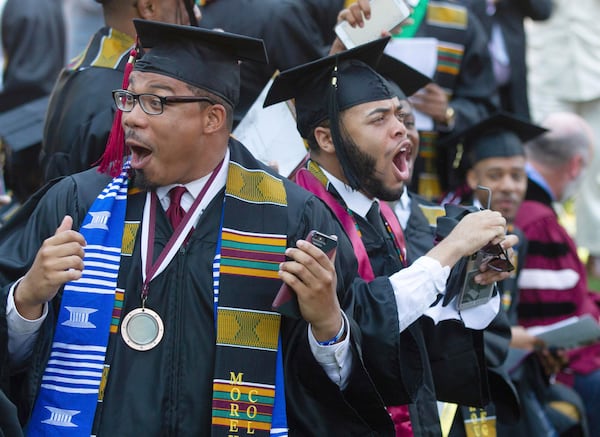 Graduates react after hearing billionaire technology investor and philanthropist Robert F. Smith say he will provide grants to wipe out the student debt of their entire graduating class at Morehouse College in Atlanta on Sunday.