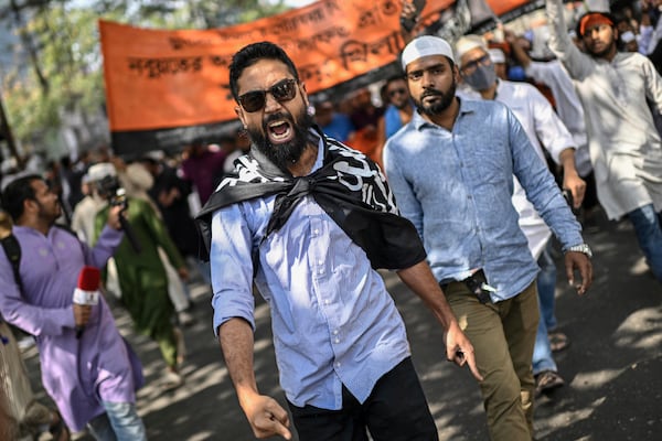 Members and supporters of the banned Islamist group Hizbut Tahrir shout slogans as they march near Baitul Mokarram Mosque in Dhaka, Bangladesh, Friday, March 7, 2025. (AP Photo/Mahmud Hossain Opu)