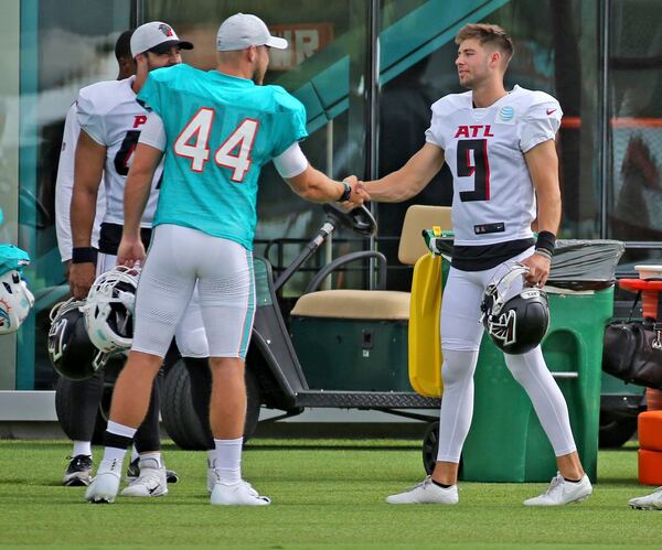 Dolphins long snapper Blake Ferguson (44) shakes hands with Falcons punter Dom Maggio (9) during a joint training camp practice at the Dolphins training facility Wednesday, Aug. 18, 2021, in Miami Gardens, Fla.  (Charles Trainor Jr./Miami Herald)