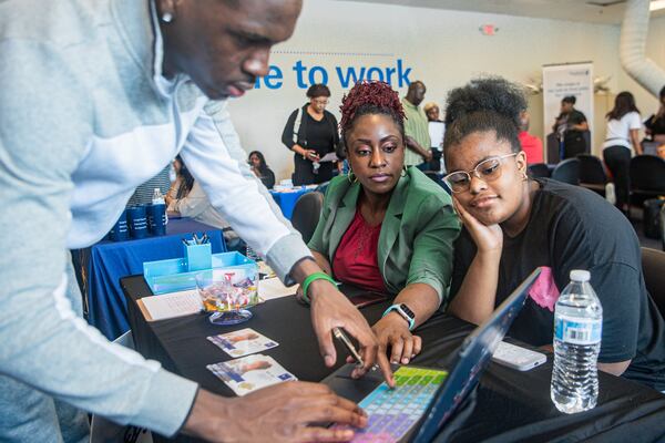 Karen Mitchell, (center), CEO of Justin Global Solutions LLC interacts with job seekers at a job fair hosted by Goodwill Career Center in Atlanta on Tuesday, July 9, 2024.  (Ziyu Julian Zhu / AJC)