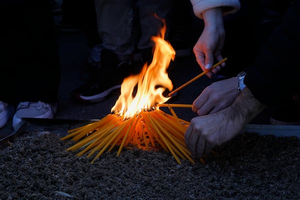 University students light candles for the victims of a massive nightclub fire in the town of Kocani, in Skopje, North Macedonia, Tuesday, March 18, 2025. (AP Photo/Boris Grdanoski)