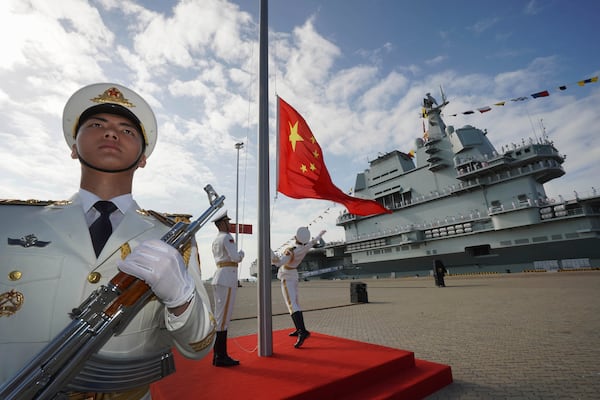 FILE - In this photo released by Xinhua News Agency, Chinese honor guard raise the Chinese flag during the commissioning ceremony of China's conventionally powered Shandong aircraft carrier at a naval port in Sanya, south China's Hainan Province, on Dec. 17, 2019. (Li Gang/Xinhua via AP, File)