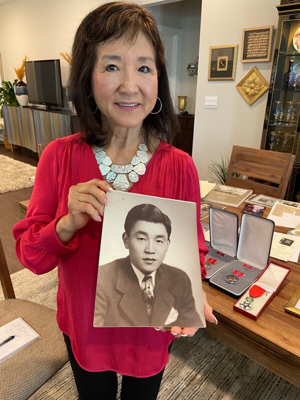 Janice "Sam" Sears holds a photo of her father, Michael Doi, who was among the Japanese American soldiers who fought in the 442nd Regimental Combat Team. Photo: Bo Emerson