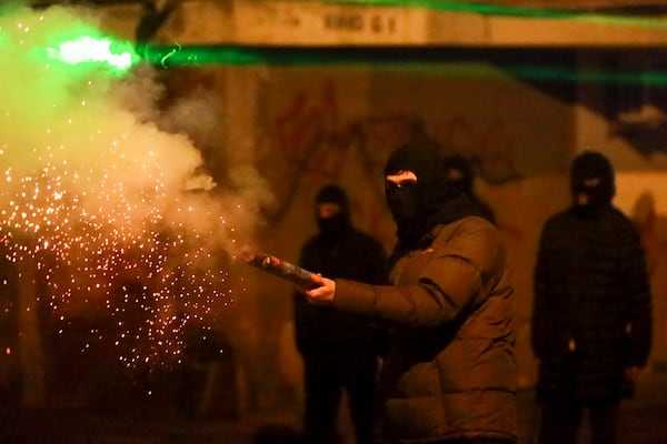 A demonstrator fires a firecracker towards police during a rally against the government's decision to suspend negotiations on joining the European Union for four years, outside the parliament's building in Tbilisi, Georgia, Monday, Dec. 2, 2024. (AP Photo/Zurab Tsertsvadze)