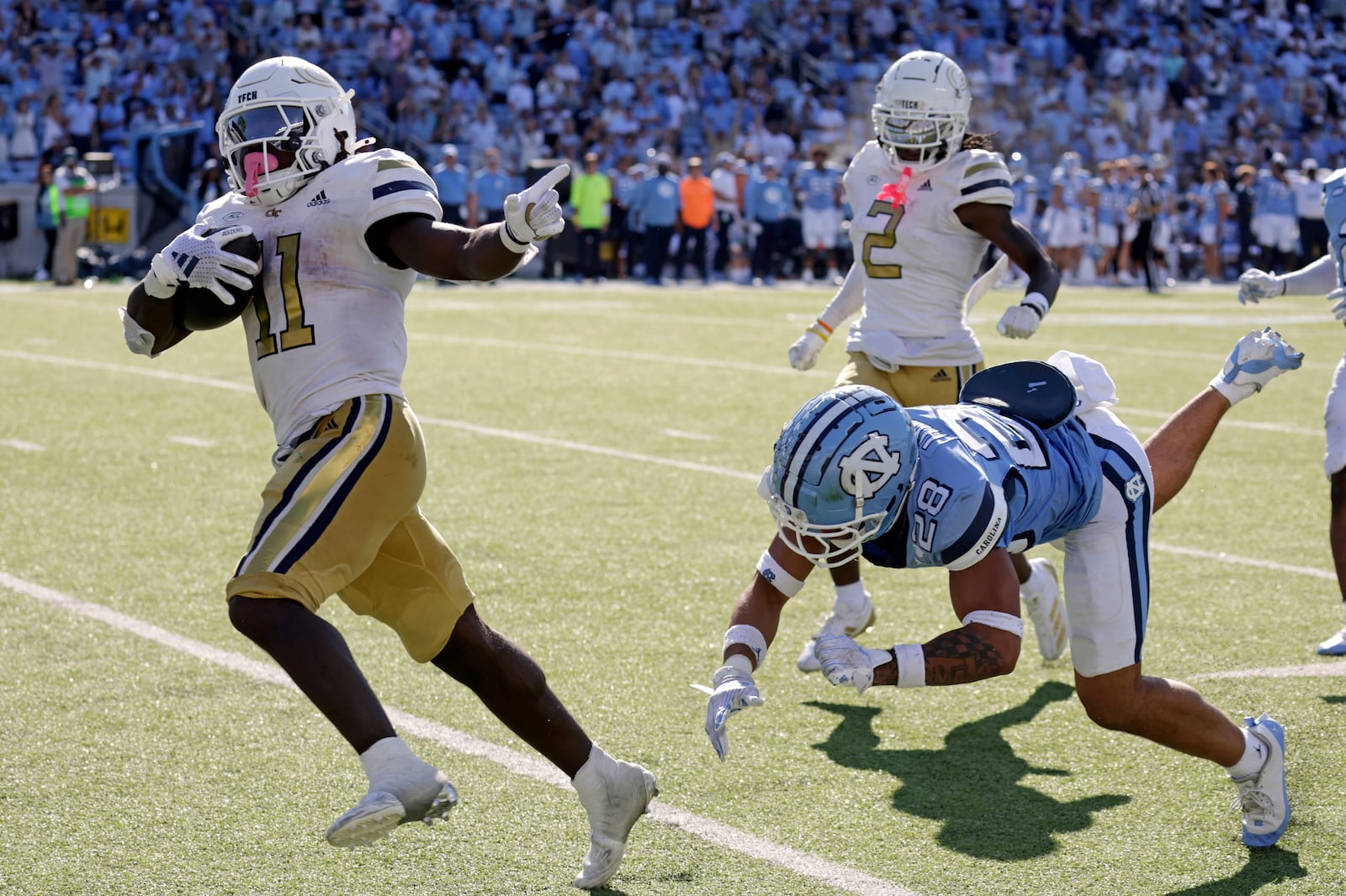 Georgia Tech running back Jamal Haynes (11) outruns North Carolina defensive back Alijah Huzzie (28) to score the winning touchdown on a long run in the closing seconds of an NCAA college football game Saturday, Oct. 12, 2024, in Chapel Hill, N.C. (AP Photo/Chris Seward)