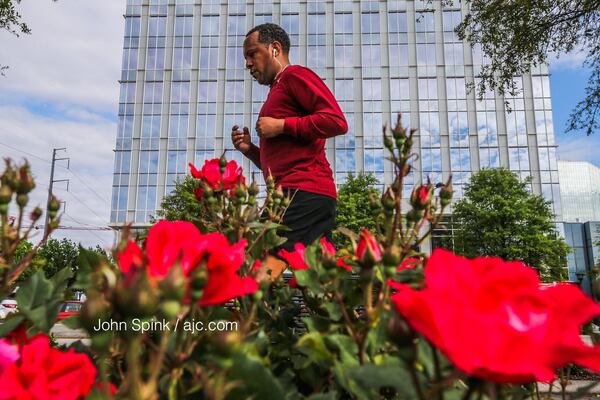 Michael McFadden preps for the Peachtree Road Race at Piedmont and Peachtree roads Monday morning. JOHN SPINK / JSPINK@AJC.COM