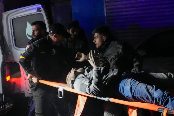 Rescuers evacuate a wounded man from the site of an Israeli airstrike in Beirut, Monday, Nov. 18, 2024. (AP Photo/Hussein Malla)