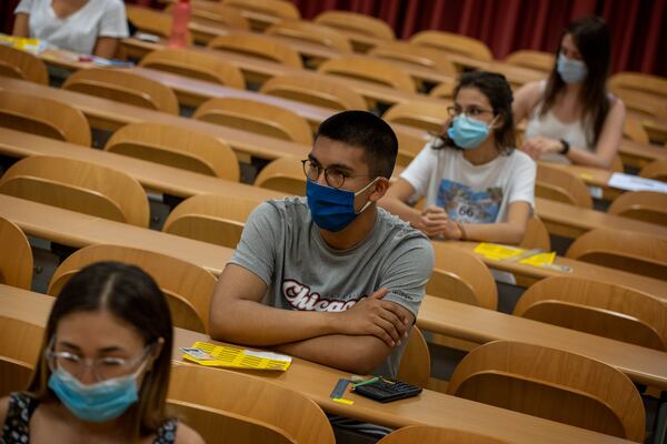 Students wearing face masks sit at their desks keeping social distance, ahead of a selectivity exam at the Autonomous University of Barcelona on Tuesday, July 7, 2020 in Sabadell, outside Barcelona, Spain. (AP Photo/Emilio Morenatti)