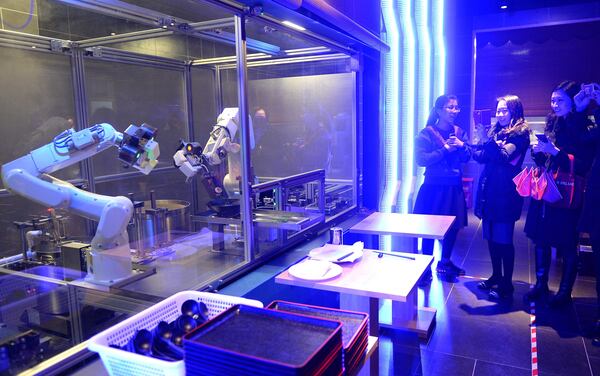 SHANGHAI, CHINA - Customers take photos of the two robots cooking noodles in a restaurant in Shanghai, China. The robots made and cooked a bowl of noodles within 90 seconds. (Photo by ChinaFotoPress/ChinaFotoPress via Getty Images)