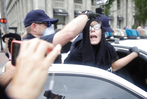 Tulsa Police officers arrest protester for trespassing after she entered the safety barricade of President Donald Trump's campaign rally Saturday June 20, 2020. (Mike Simons/Tulsa World via AP)