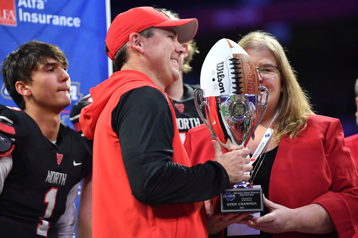 North Oconee head coach Tyler Aurandt is all smiles as he receives his first place trophy after beating Marist 14-7 in a  Class 4A championship game at the Mercedes-Benz Stadium Monday, Dec. 16, 2024. (Photo/Daniel Varnado)