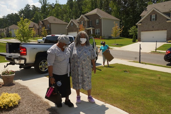 Janice Cockfield (right), steadied by her sister Drucilla Burgess, arrives at her South Fulton home on July 17, 2020, for the first time since being hospitalized for 110 days because of COVID-19. (Credit: Janese Cockfield / Contributed)