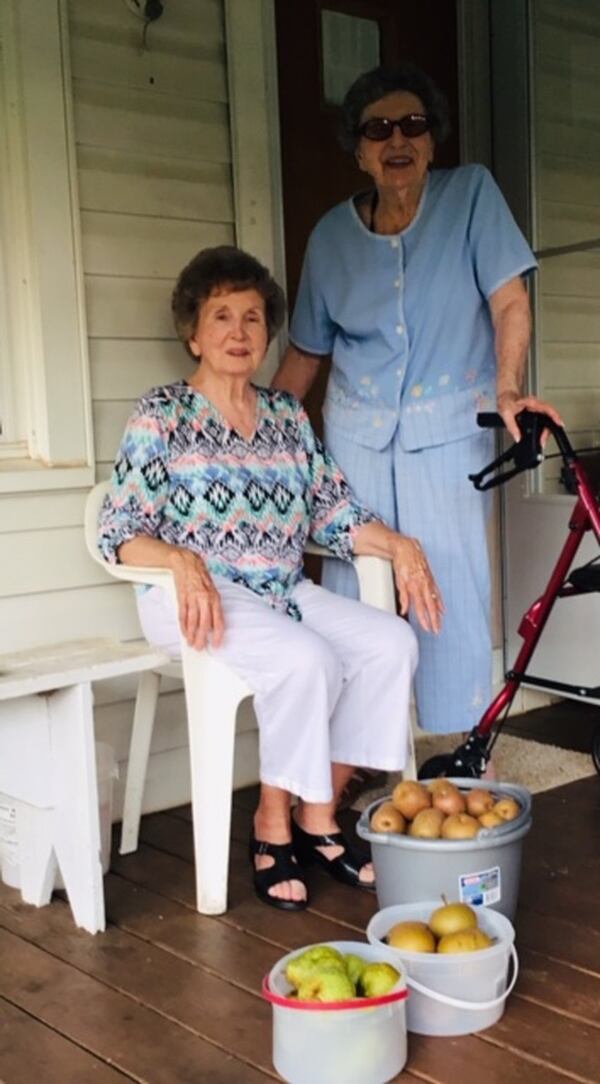 Margaret Stancil standing next to her sister Jane after gathering pears at their home near Ball Ground. 