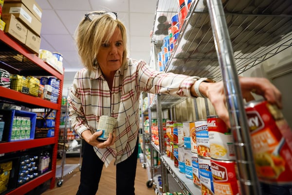 Volunteer Janice St. Hilaire stocks dry food items at the Community Market before opening on Thursday, Dec. 14, 2023.
Miguel Martinez /miguel.martinezjimenez@ajc.com