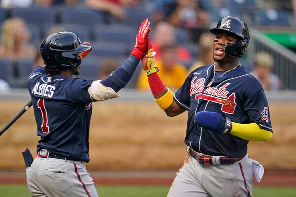 Atlanta Braves' Ronald Acuna Jr., right, is greeted by Ozzie Albies after scoring on a double by Freddie Freeman during the first inning of a baseball game in Pittsburgh, Monday, July 5, 2021. (AP Photo/Gene J. Puskar)