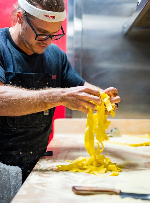 Chef Bruce Logue tosses tagliatelle noodles in semolina flour at BoccaLupo. CONTRIBUTED BY HENRI HOLLIS