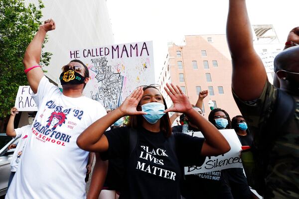 In this June 6, 2020, photo, Maisie Brown, 18, second from left, a member of the Mississippi branch of Black Lives Matter, leads a protest march with others during a rally in Jackson, Miss., over police brutality. Young activists like Brown are energizing the debate about removing the Confederate battle emblem from the Mississippi state flag. Brown says elected officials must step up and change the flag. (AP Photo/Rogelio V. Solis)