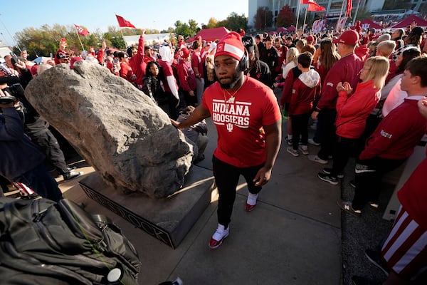 Indiana football players touch "Hep's Rock" and they enter Memorial Stadium before an NCAA college football game against the Washington, Saturday, Oct. 26, 2024, in Bloomington, Ind. (AP Photo/Darron Cummings)