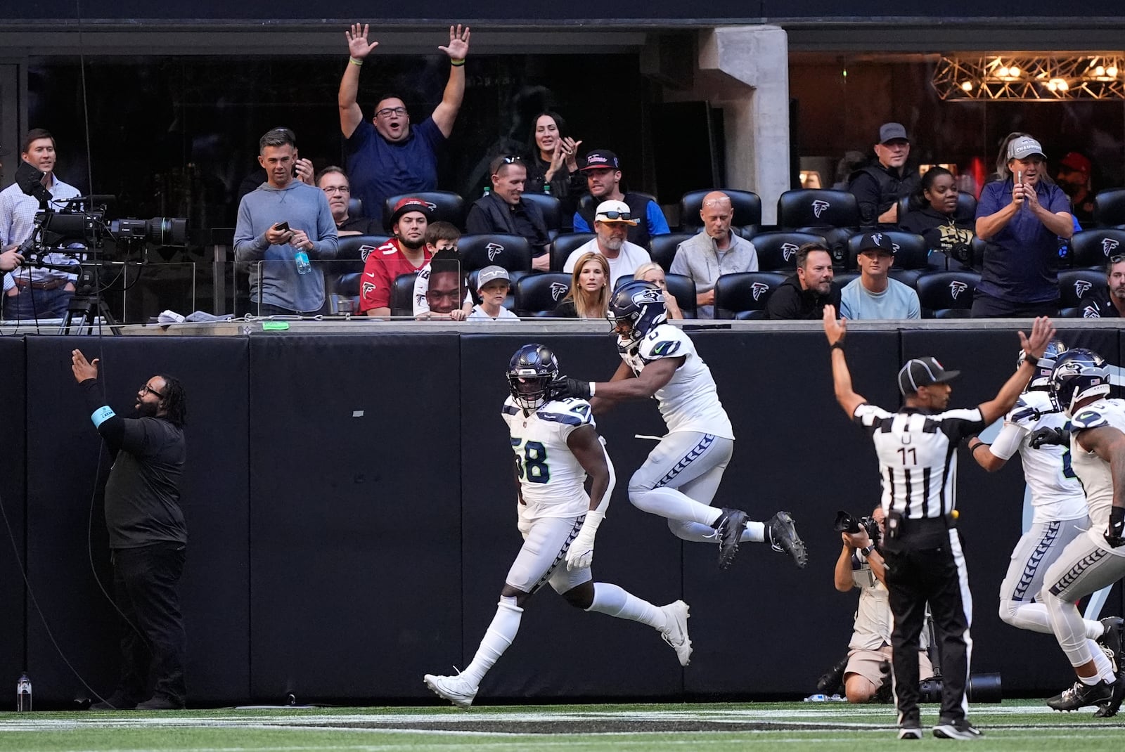 Seattle Seahawks linebacker Derick Hall (58) celebrates with Tyrel Dodson (0) after returning a fumble for a touchdown during the second half of an NFL football game against the Atlanta Falcons , Sunday, Oct. 20, 2024, in Atlanta. (AP Photo/Brynn Anderson)