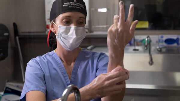 Dr. Brittany Bankhead-Kendall scrubs her arms and hands at Texas Tech University Medical Center. Nationwide, doctors and other health professionals have been called on to work double duty during the pandemic.(Courtesy of Dr. Brittany Bankhead-Kendall)