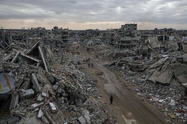 People walk amid the destruction caused by the Israeli air and ground offensive in Rafah on Monday.