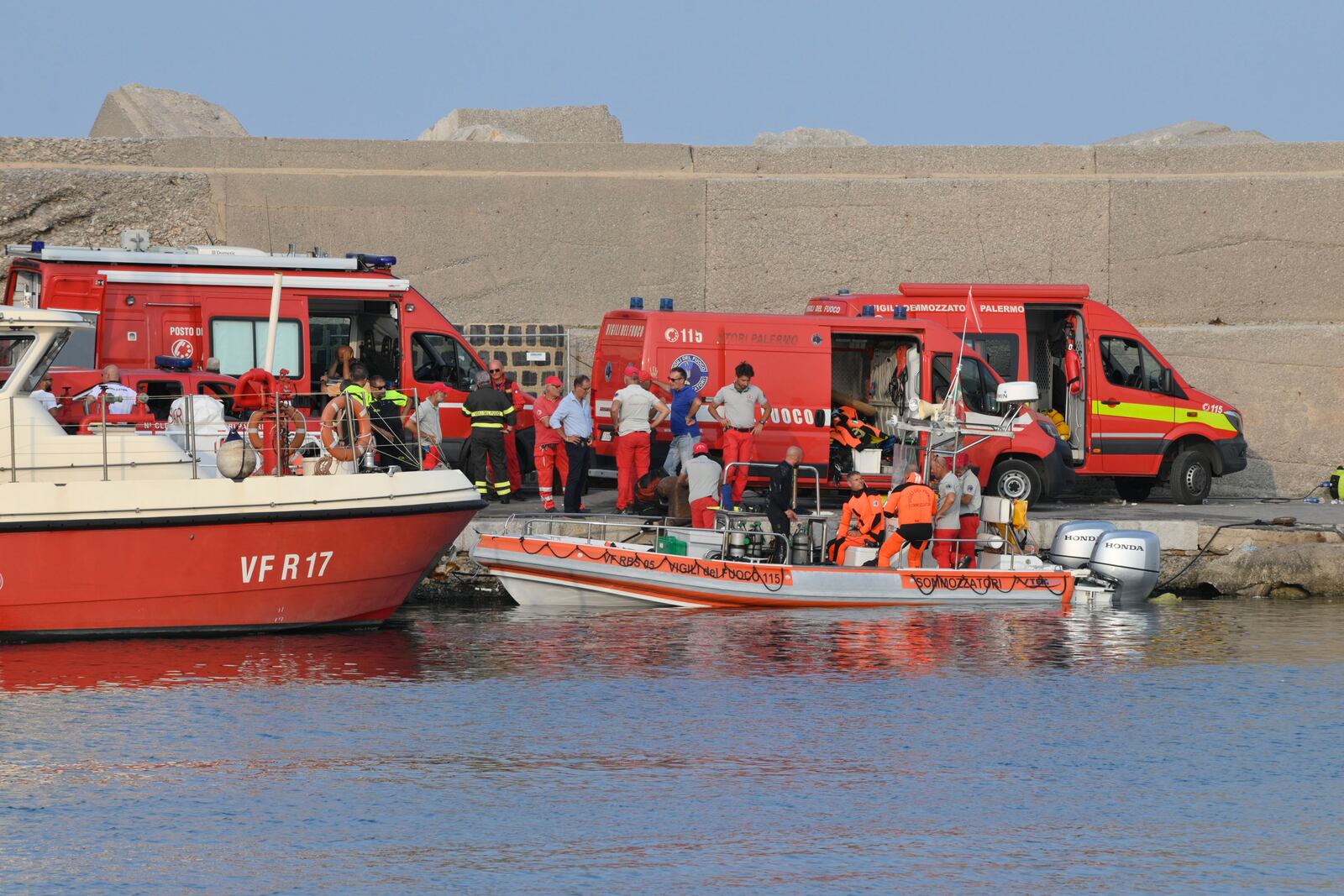 Italian Firefighters scubadivers prepare to sail toward the area where the UK flag vessel Bayesan that was hit by a violent sudden storm, sunk early Monday, Aug. 19, 2024, while at anchor off the Sicilian village of Porticello near Palermo, in southern Italy. (AP Photo/Lucio Ganci)