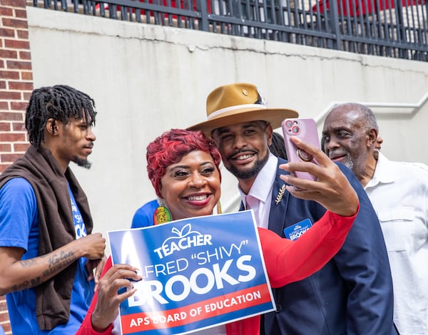 Alfred "Shivy" Brooks kicks off his campaign for Atlanta Public Schools Board of Education across the street from Maynard Jackson High School on Friday, June 16, 2023.  Brooks, a high school teacher, poses with Atlanta activist Porch'se Miller after the formal announcement. (Jenni Girtman for The Atlanta Journal-Constitution)